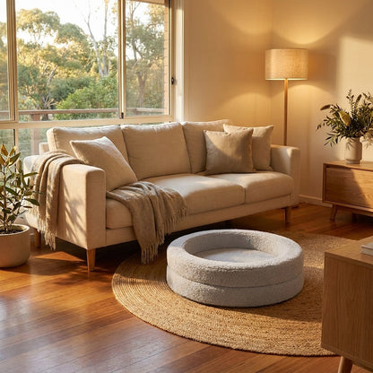 The Calming Nest light grey plush nest dog bed by a sofa in the evening | PawHaus Co |c:Light Grey