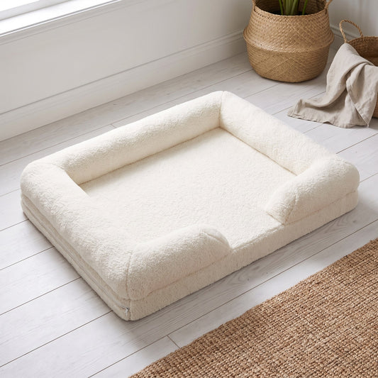 The Bouclé Sofa in cream, raised three-quarter view showing the low profile and the bolster wrapping three sides | PawHaus Co |c:White