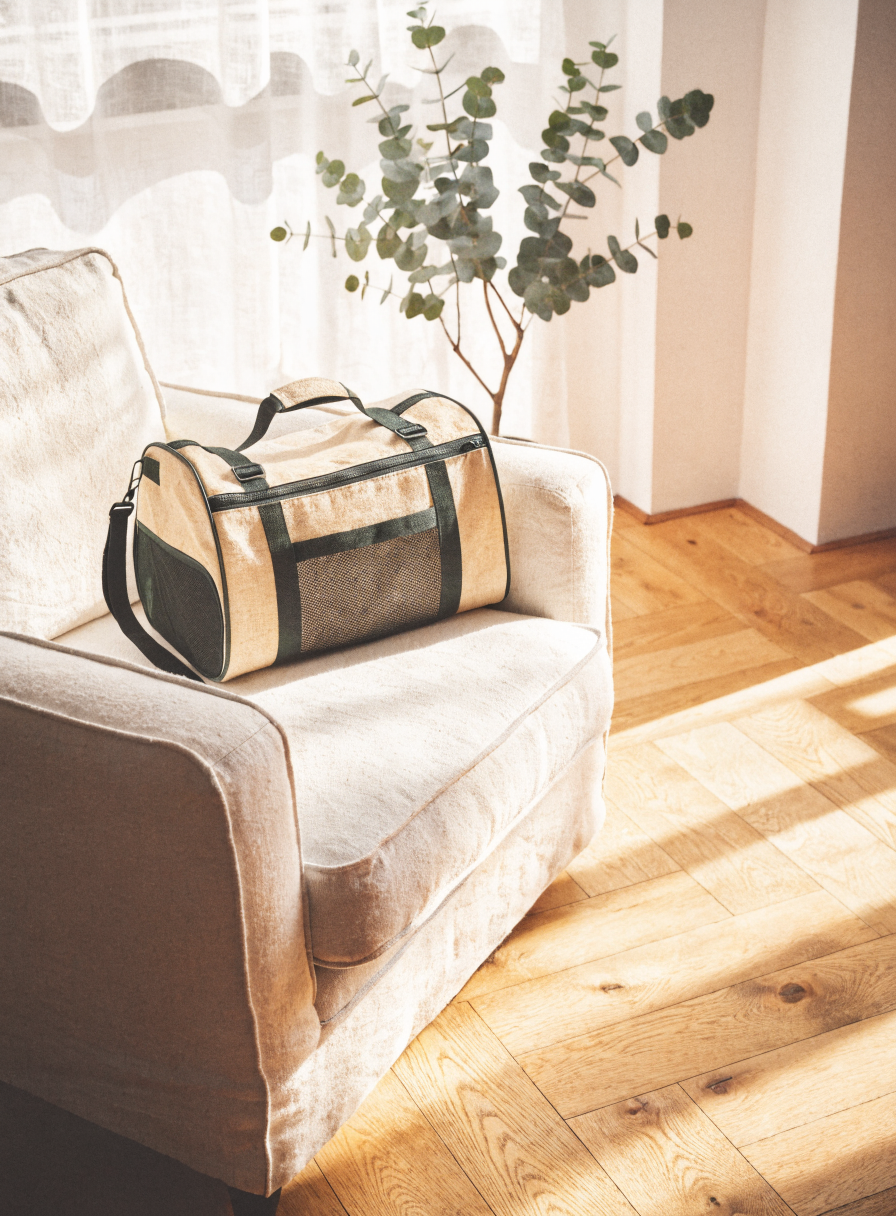 PawHaus Co The Carrier — stylish soft dog carrier on linen armchair